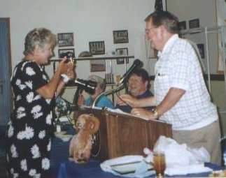 Loser of the "Who's Who?" contest Gerrie DAY Telander, accepting her "Award(?)" from Milton Clinard